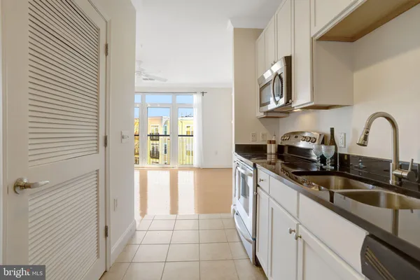 a kitchen with stainless steel appliances granite countertop a sink and a stove