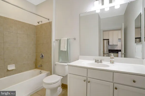 a bathroom with a sink a toilet a mirror a bathtub and shower