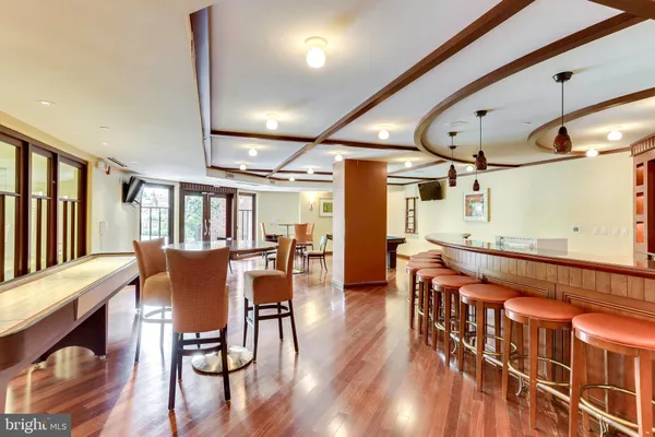 a dining room with furniture a chandelier and wooden floor
