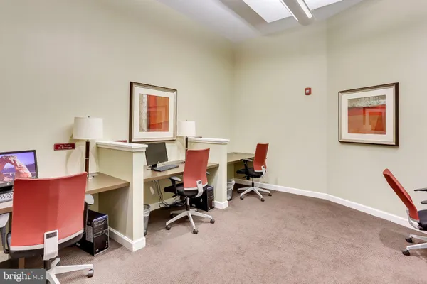 a view of a workspace with furniture and a window
