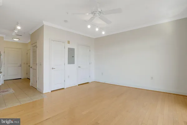 an empty room with an entryway and chandelier fan