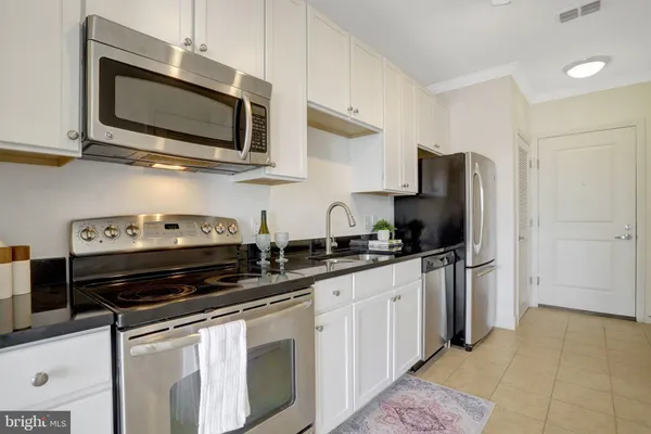a kitchen with stainless steel appliances a stove microwave and refrigerator