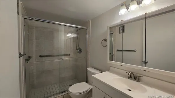 a bathroom with a sink mirror shower and toilet
