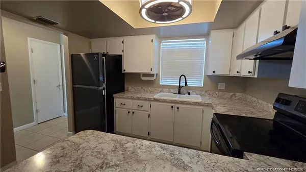 a kitchen with a refrigerator and a sink