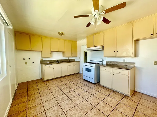 a kitchen with granite countertop cabinets and white stainless steel appliances