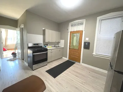 a kitchen with a refrigerator and wooden floor