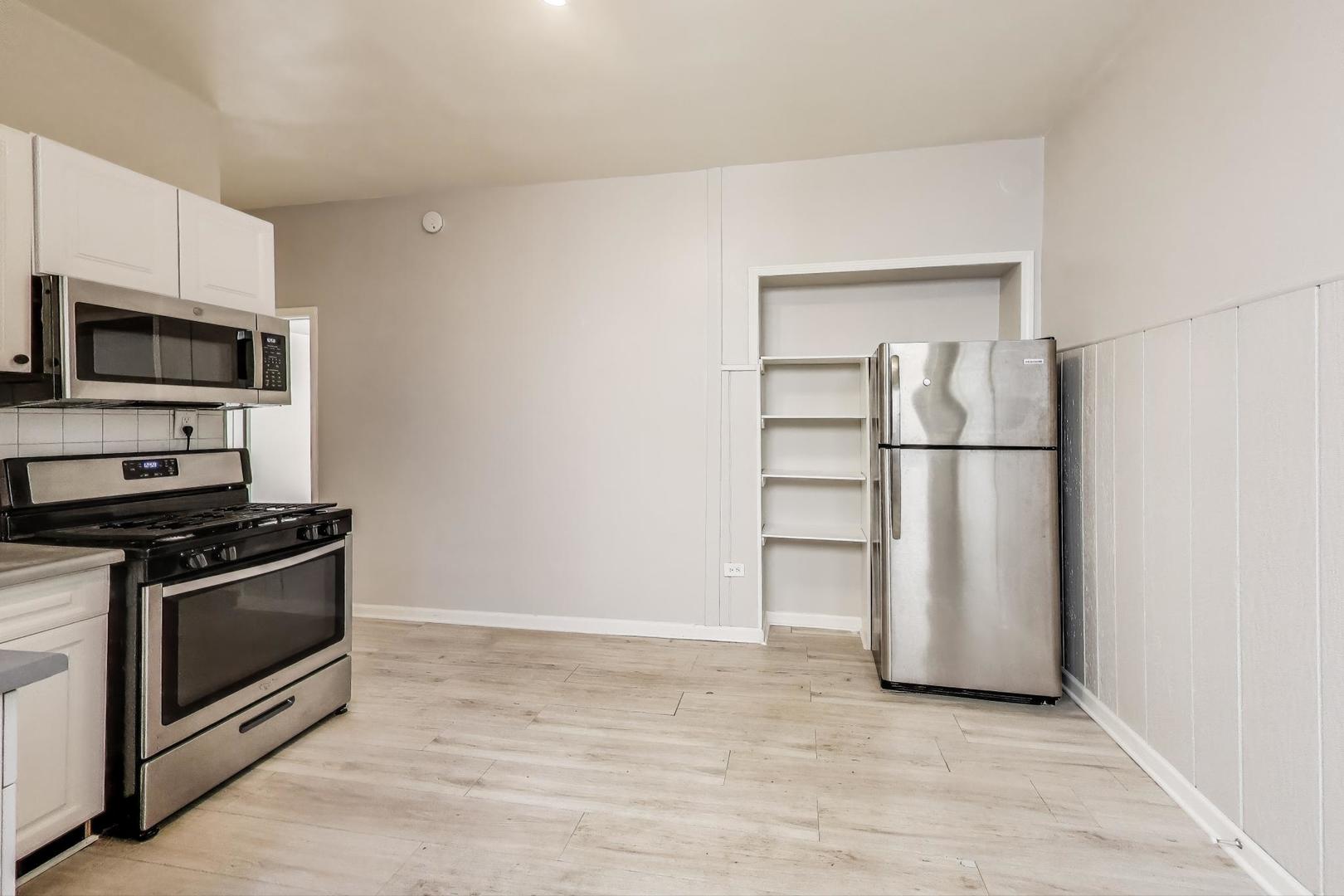 2889 North Milwaukee Avenue Chicago, IL 60618 - Photo 4 of 17 a kitchen with a stove and a refrigerator