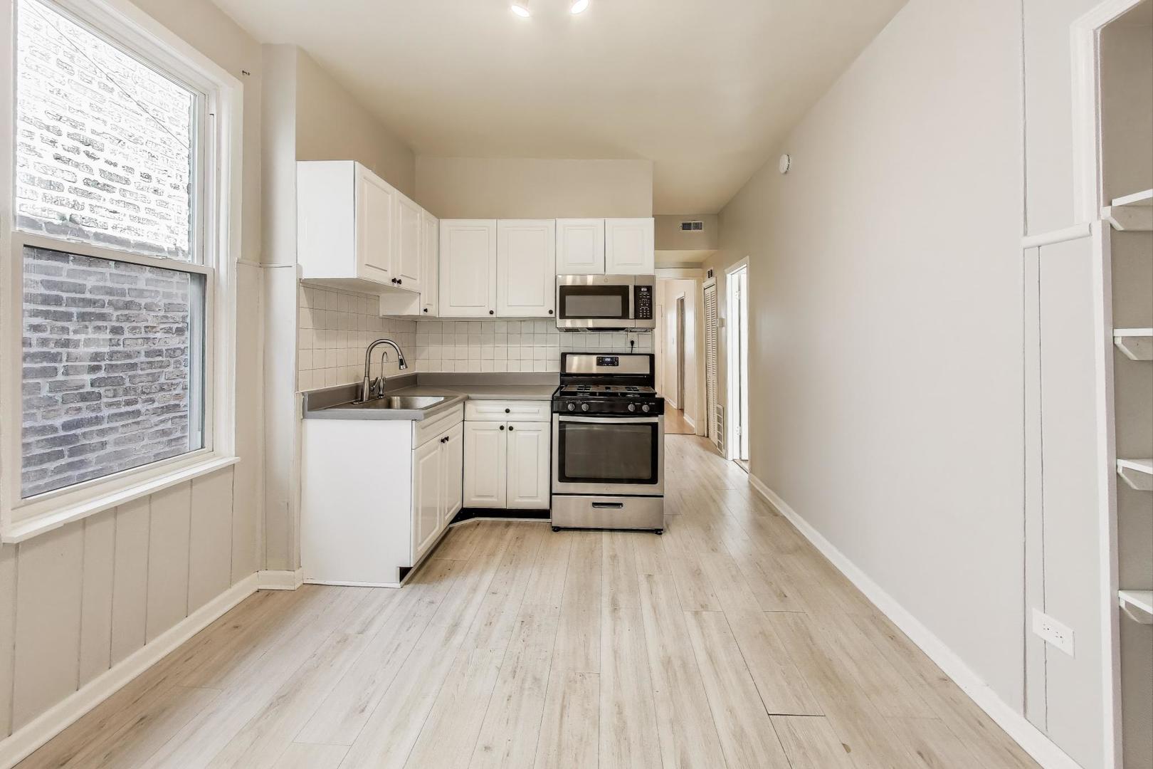 2889 North Milwaukee Avenue Chicago, IL 60618 - Photo 6 of 17 a kitchen with stainless steel appliances a refrigerator sink and cabinets