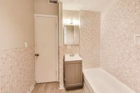 a bathroom with a tub sink and mirror