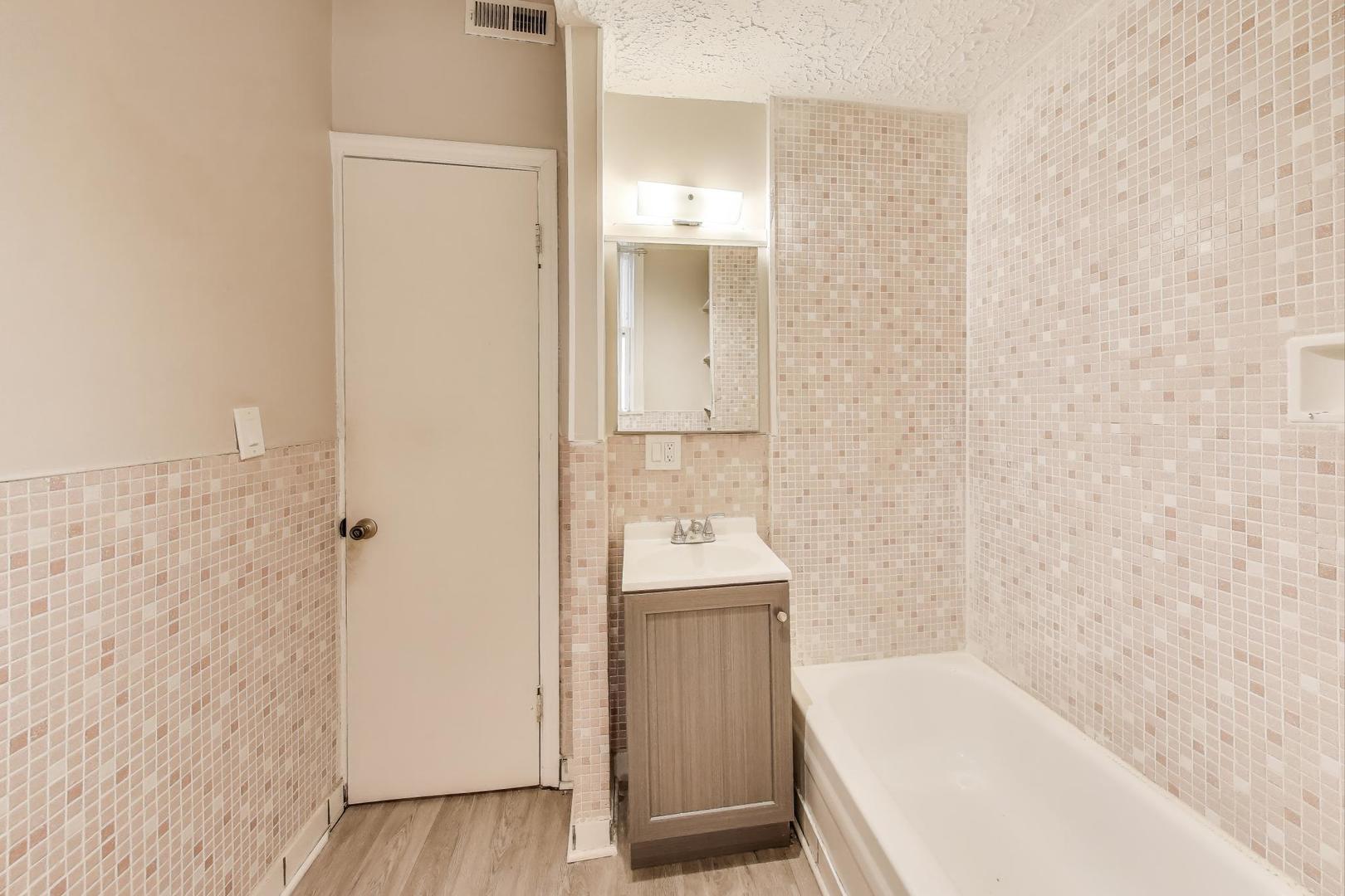 2889 North Milwaukee Avenue Chicago, IL 60618 - Photo 7 of 17 a bathroom with a tub sink and mirror