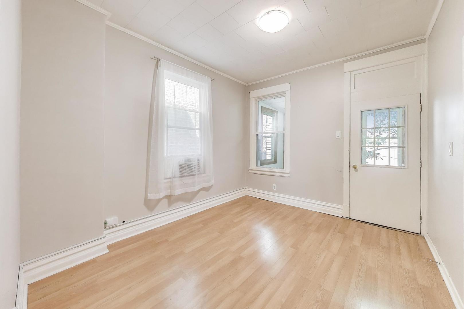 2889 North Milwaukee Avenue Chicago, IL 60618 - Photo 8 of 17 an empty room with wooden floor and windows