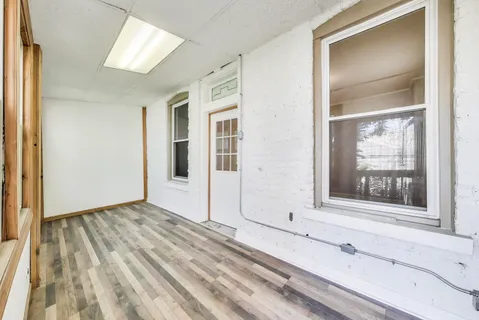 a view of a livingroom with wooden floor and a window