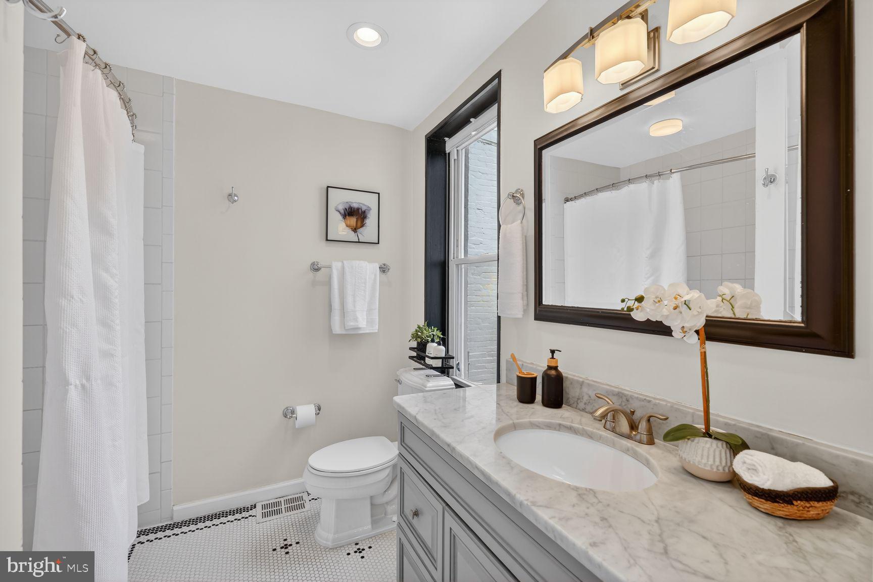 624 14th Place Northeast Washington, DC 20002 - Photo 19 of 25 a bathroom with a granite countertop toilet sink and mirror