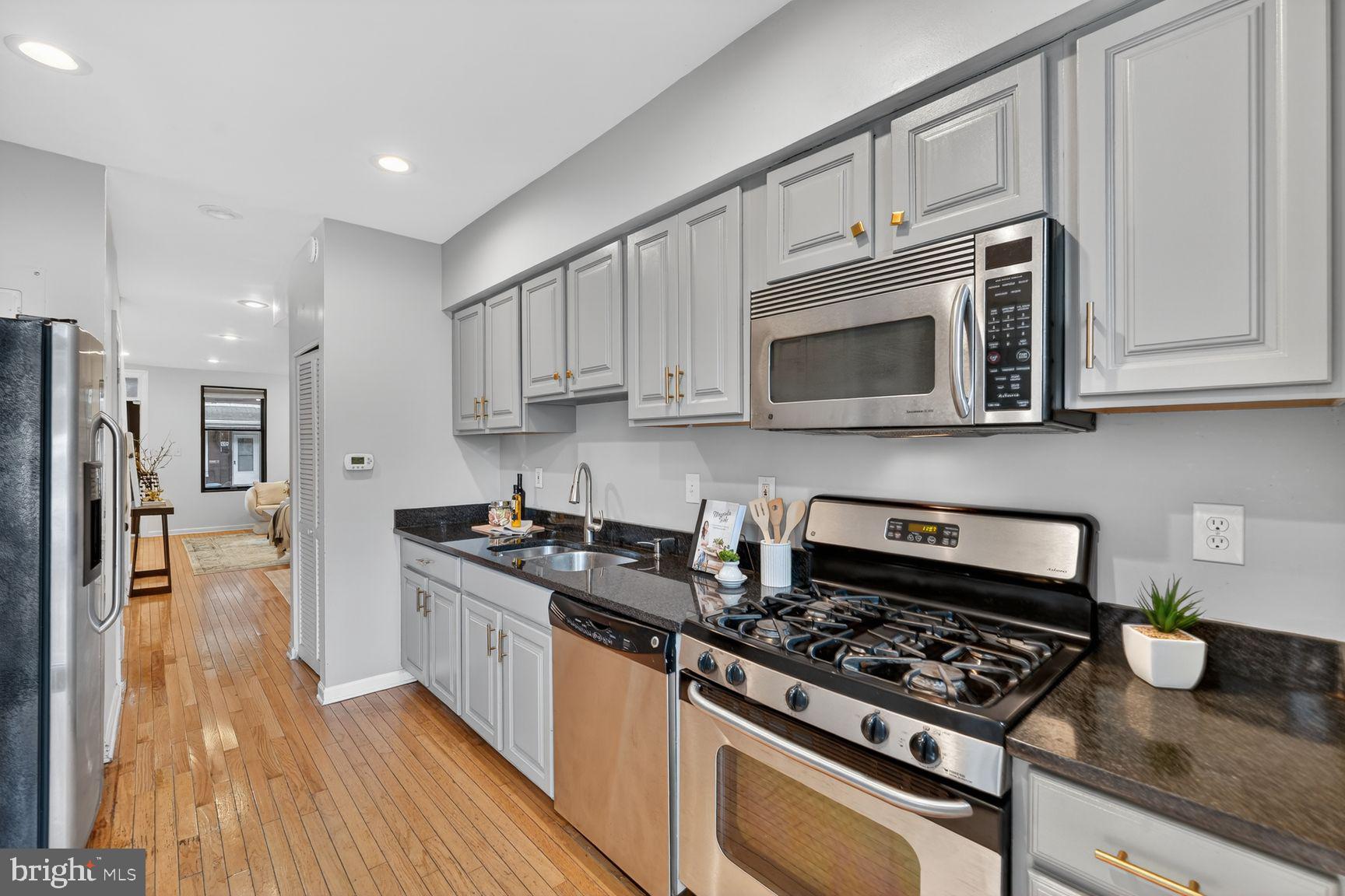 624 14th Place Northeast Washington, DC 20002 - Photo 10 of 25 a kitchen with stainless steel appliances granite countertop a stove a microwave and a refrigerator