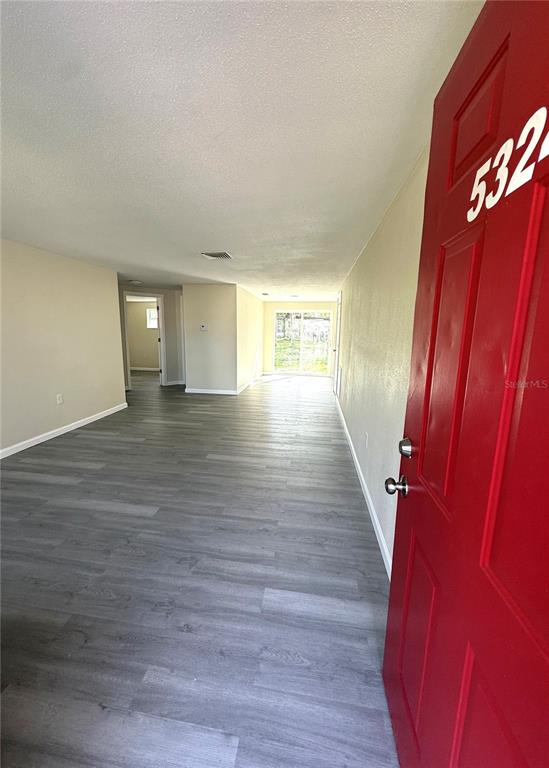5318 Cedar Lane New Port Richey, FL 34652 - Photo 4 of 32 a view of an empty room with wooden floor and a window