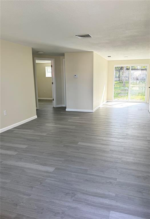 5318 Cedar Lane New Port Richey, FL 34652 - Photo 5 of 32 a view of empty room with window and wooden floor