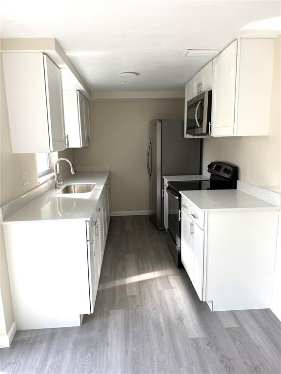 5318 Cedar Lane New Port Richey, FL 34652 - Photo 7 of 32 a kitchen with granite countertop a sink and a stove top oven