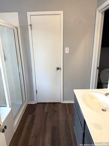 a view of bathroom with a sink window and wooden floor
