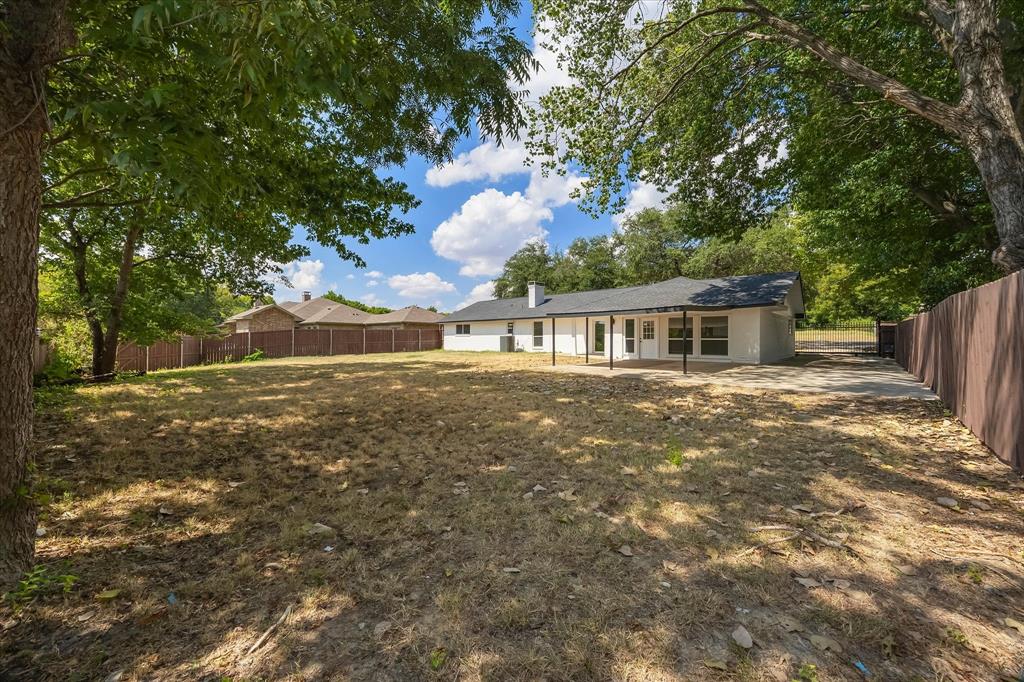 925 Lake North Road Rowlett, TX 75089 - Photo 28 of 37 Expansive lot with mature trees, fenced perimeter, rear patio, and a dedicated driveway