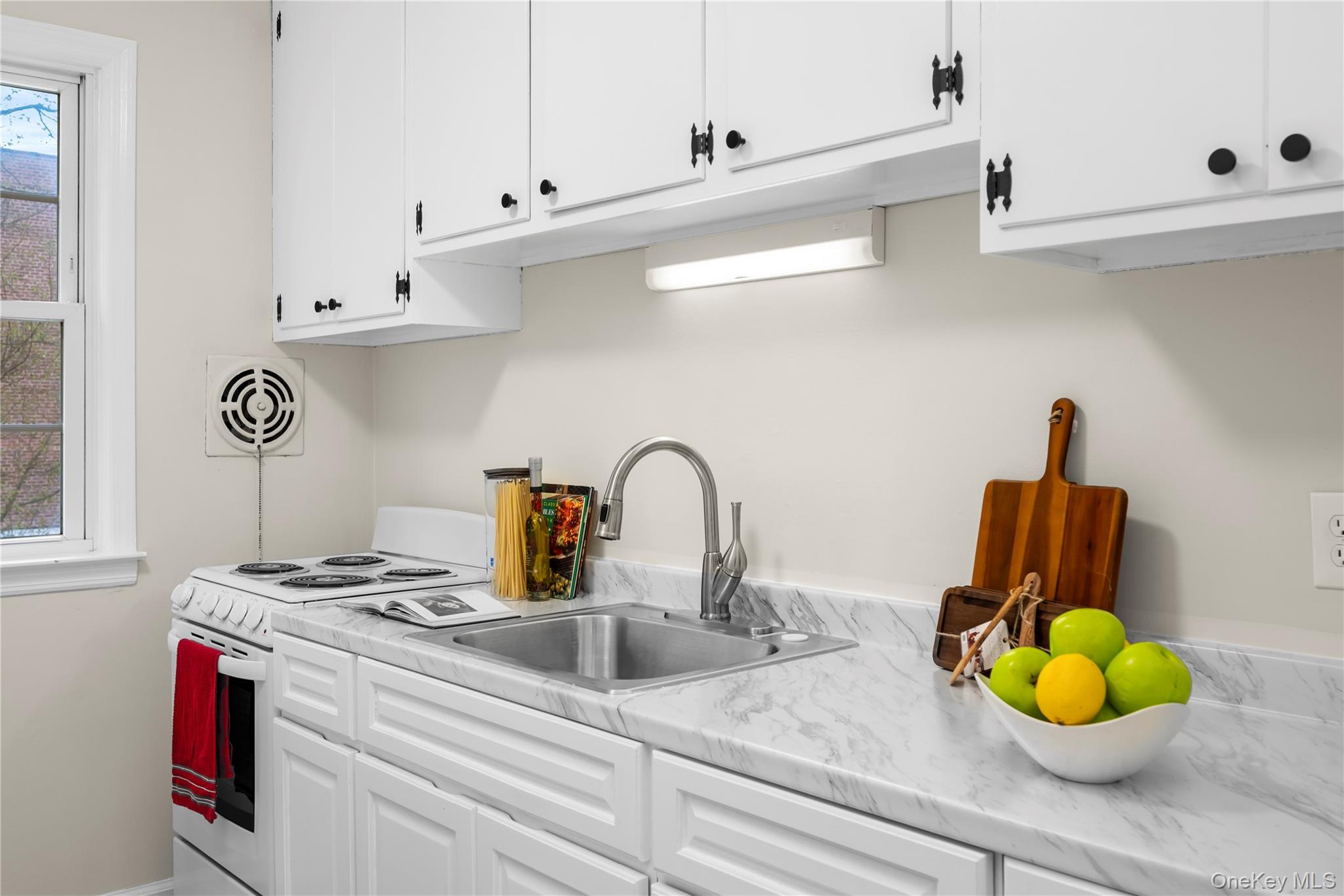 Kitchen featuring a stainless steel sink with a gooseneck faucet, a white electric range, and laminate countertops with a marble-effect finish