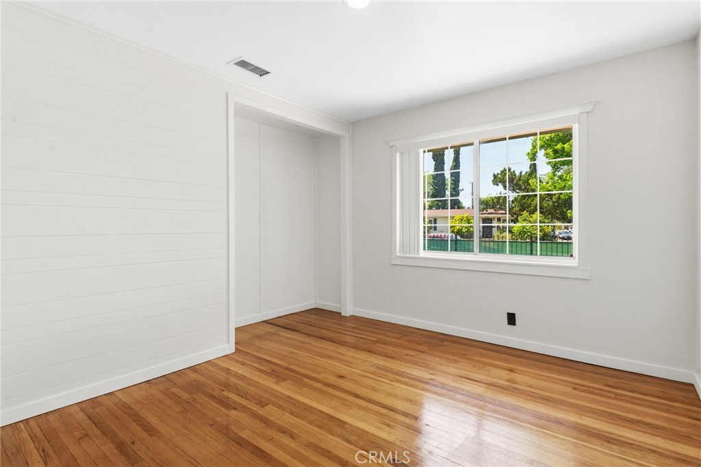 8040 Ranchito Avenue Panorama City, CA 91402 - Photo 15 of 64 a view of an empty room with wooden floor and a window