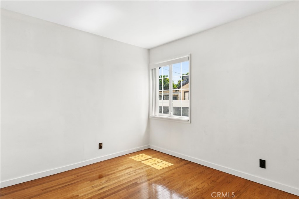 8040 Ranchito Avenue Panorama City, CA 91402 - Photo 20 of 64 a view of an empty room with wooden floor and a window