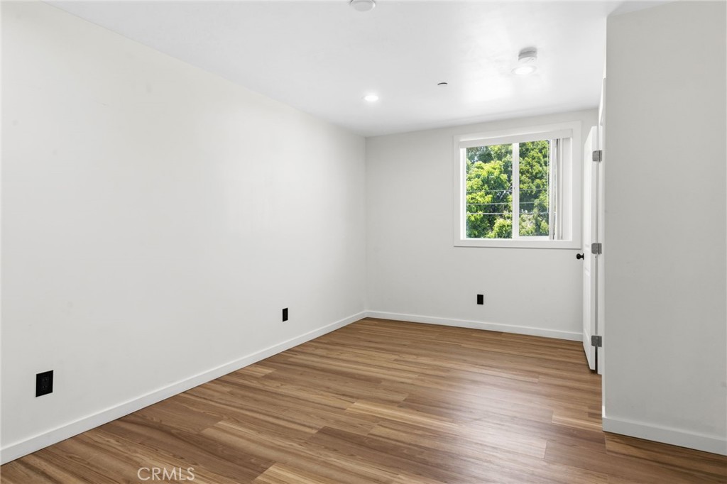 8040 Ranchito Avenue Panorama City, CA 91402 - Photo 33 of 64 an empty room with wooden floor and windows