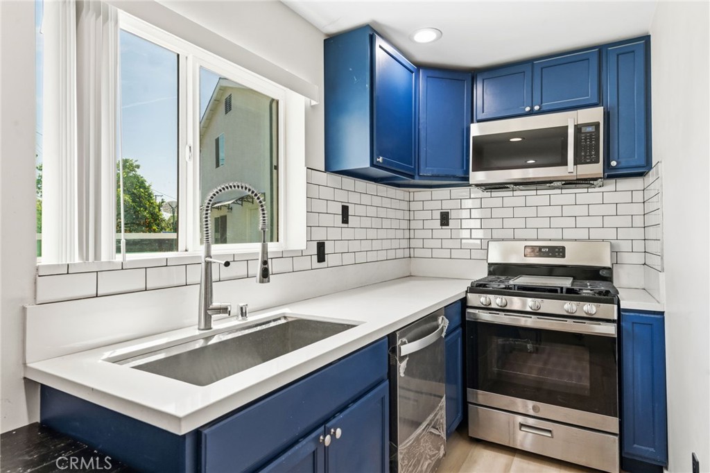 8040 Ranchito Avenue Panorama City, CA 91402 - Photo 51 of 64 a kitchen with stainless steel appliances wooden cabinets stove top oven and sink