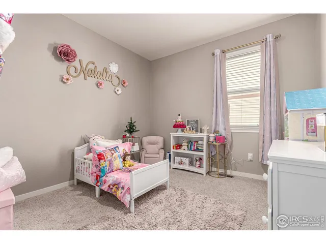 a living room with furniture and a baby crib