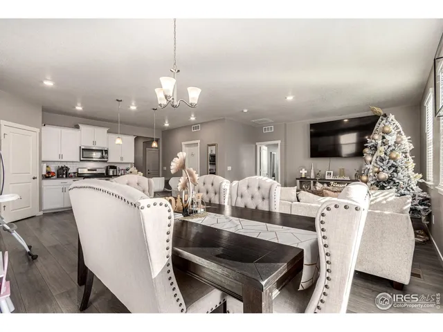 a living room with furniture a flat screen tv and kitchen view