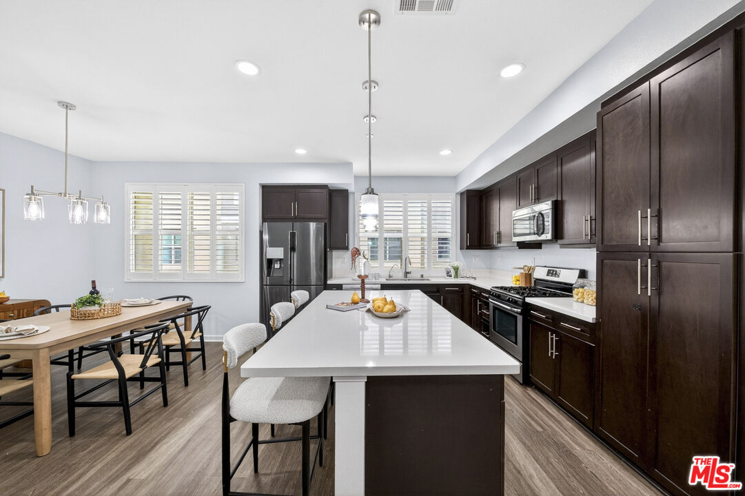 676 Colorado Circle Carson, CA 90745 - Photo 12 of 36 a kitchen with refrigerator a sink and chairs