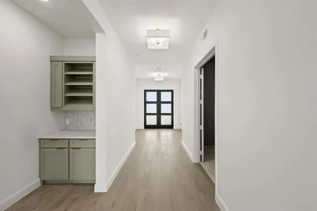 a view of a hallway with wooden floor and entryway