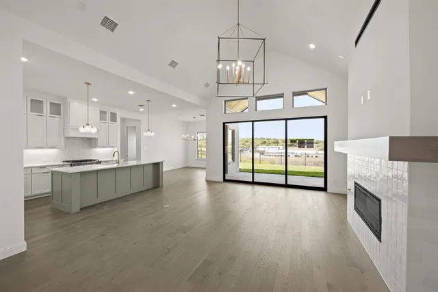 a large kitchen with a large window a sink stainless steel appliances and cabinets