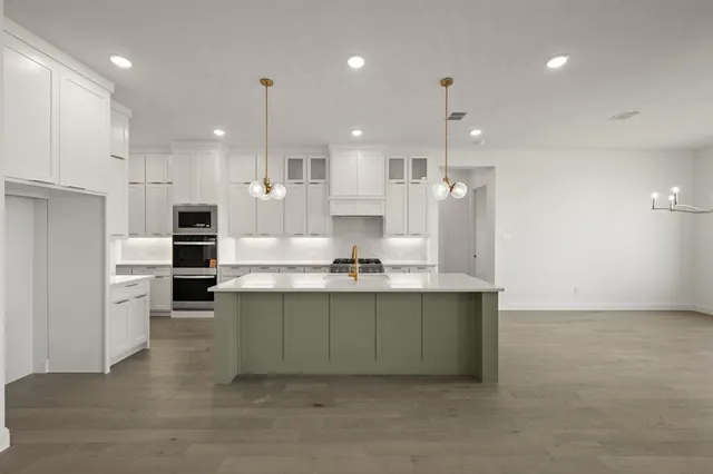 a large kitchen with a large counter top appliances and cabinets