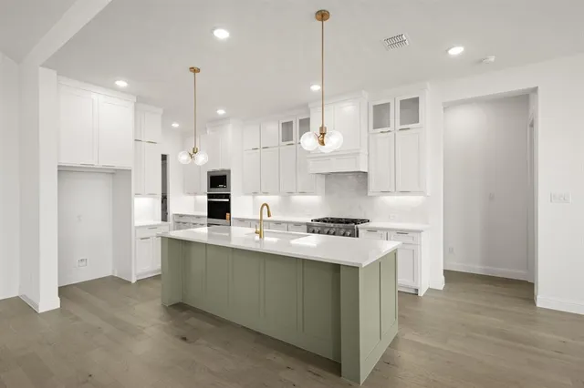 a kitchen with stainless steel appliances sink stove and refrigerator