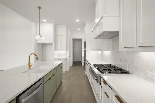 a kitchen with kitchen island a sink stove and refrigerator