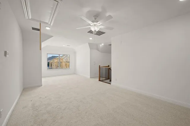 en empty room with windows and ceiling fan