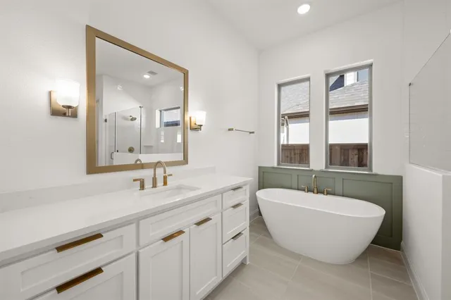 a spacious bathroom with a double vanity sink a mirror and a bathtub