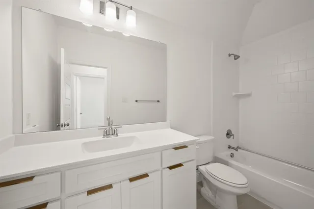 a bathroom with a sink toilet vanity and tub