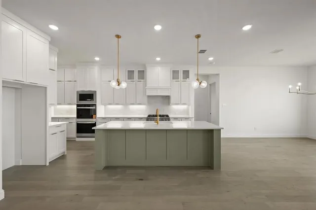 a large kitchen with a large counter top appliances and cabinets