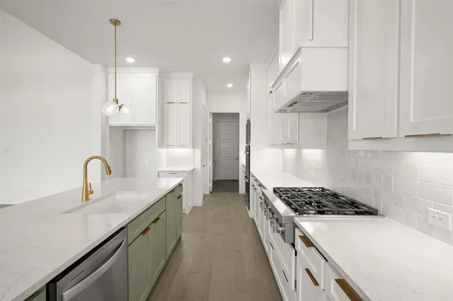 a kitchen with kitchen island a sink stove and refrigerator