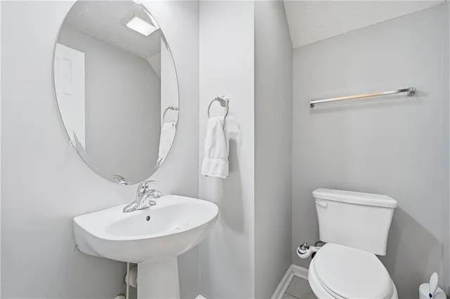 a bathroom with a sink a toilet and a mirror