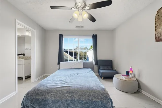 a bedroom with furniture and a chandelier fan