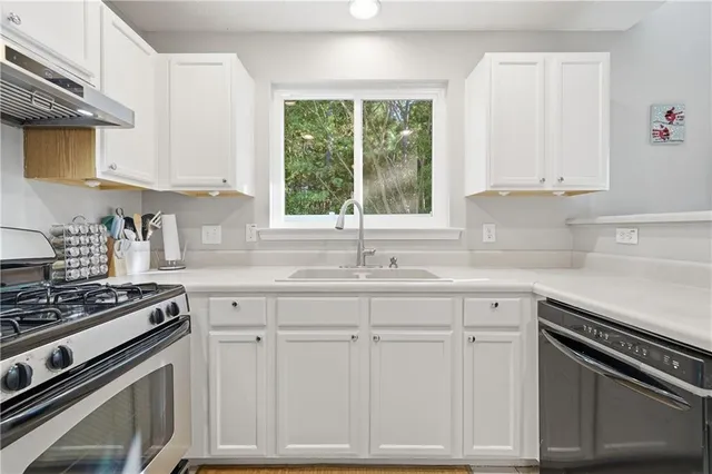 a kitchen with white cabinets and appliances