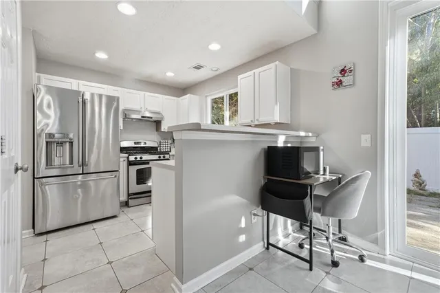 a kitchen with kitchen island a counter top space appliances and cabinets