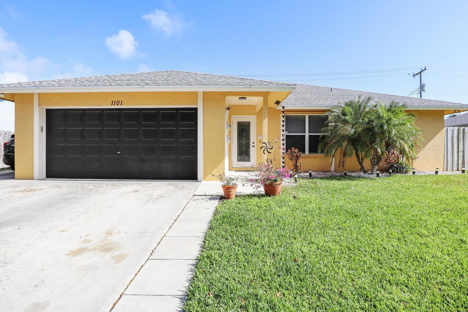 1101 Julia Heights Drive Lantana, FL 33462 - Photo 1 of 19 a front view of a house with a yard and garage