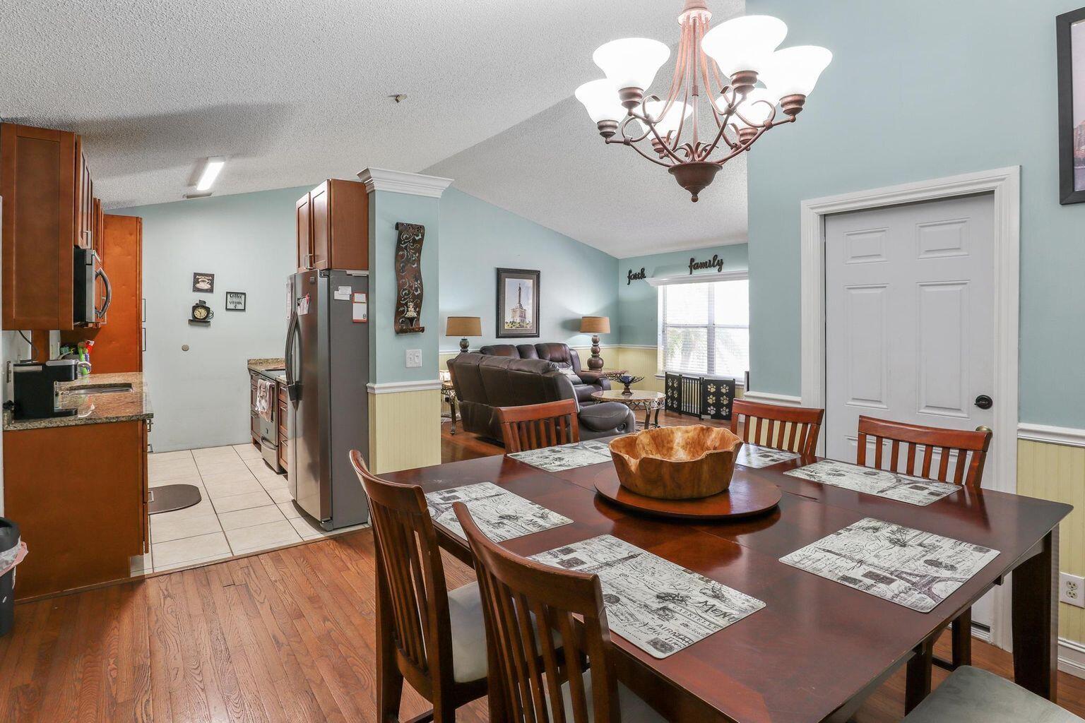 1101 Julia Heights Drive Lantana, FL 33462 - Photo 5 of 19 a dining room with furniture a chandelier and wooden floor