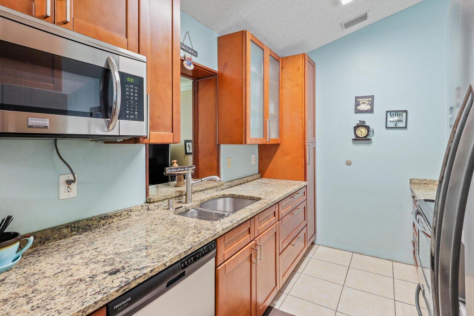 1101 Julia Heights Drive Lantana, FL 33462 - Photo 7 of 19 a kitchen with stainless steel appliances granite countertop a sink and a microwave