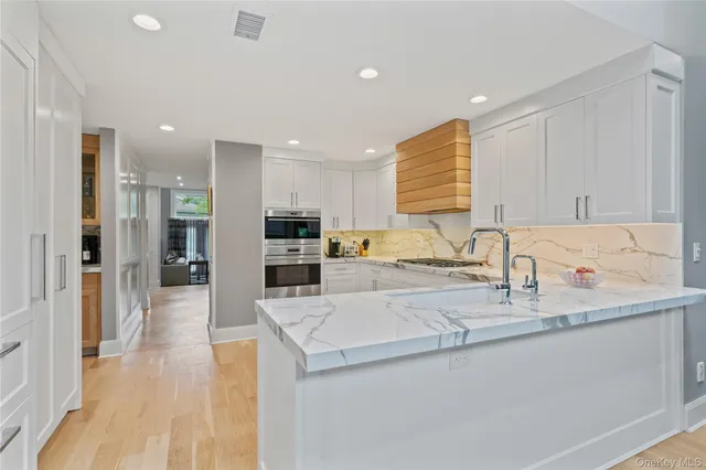 a kitchen with stainless steel appliances granite countertop a sink and a refrigerator