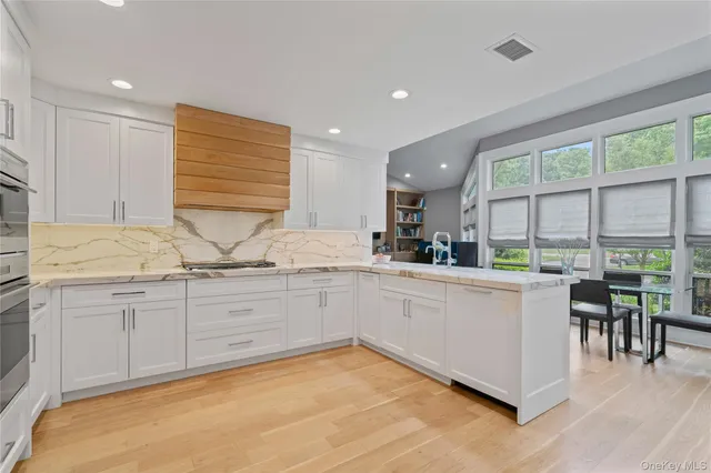 a kitchen with granite countertop a sink and white cabinets